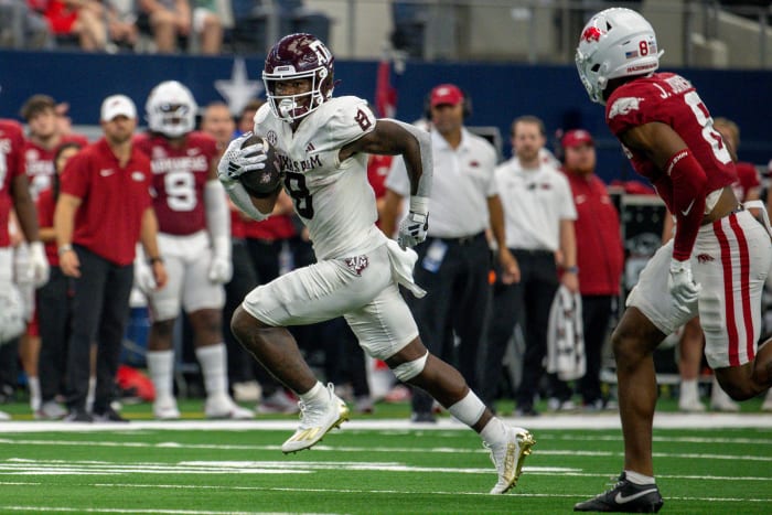 Texas A&M Aggies running back Le'Veon Moss (8) and Arkansas Razorbacks defensive back Jayden Johnson (8) In action during the game between the Texas A&M Aggies and the Arkansas Razorbacks at AT&T Stadium